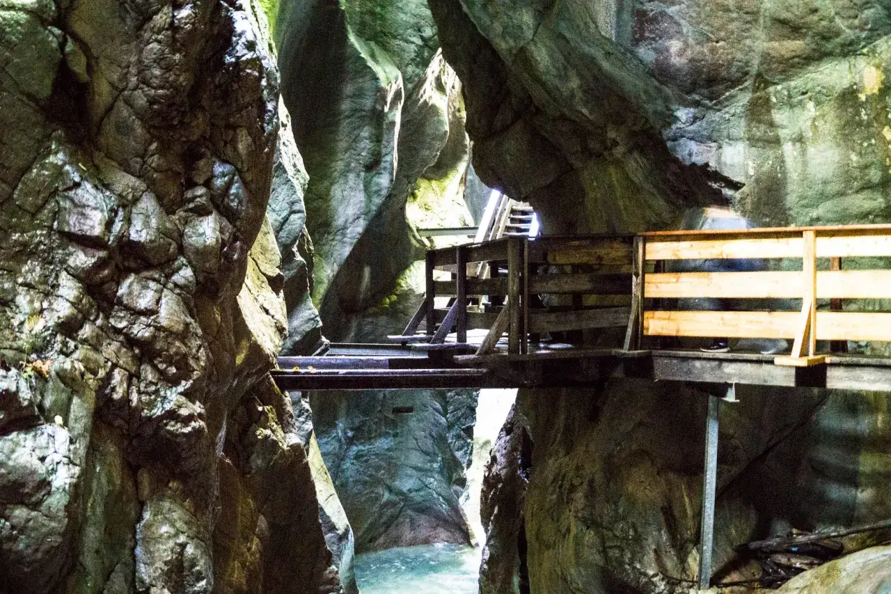 Holzstege führen durch eine enge Schlucht mit türkisblauem Wasser. Ein spannendes Erlebnis beim klamm wandern.