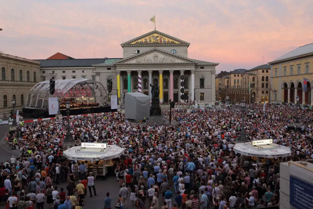Gro&szlig;e Menschenmenge auf dem Max-Joseph-Platz vor dem Nationaltheater bei einem Open-Air-Konzert im Abendrot.
