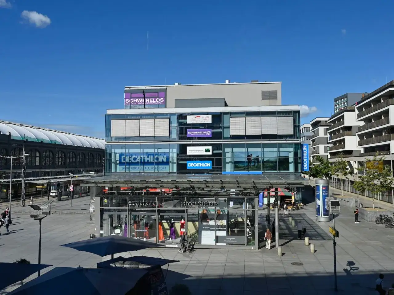 Moderne Gebäude am Wiener Platz mit Decathlon-Geschäften und einem Restaurant.