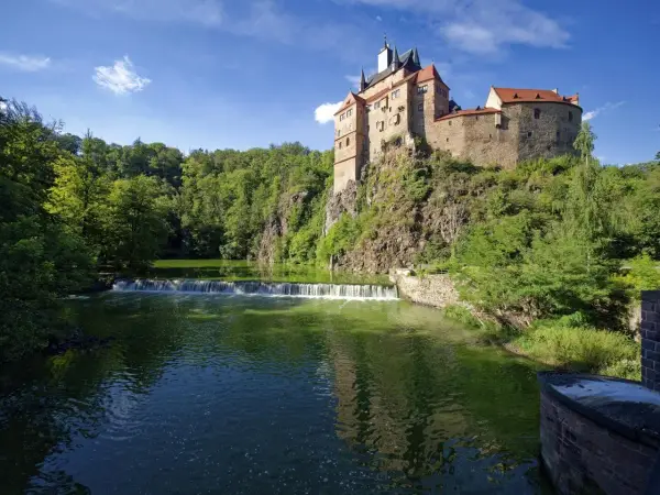 Burg Kriebstein, ein malerisches Schloss auf einem Felsen über einem Fluss mit Wasserfall, ist ein tolles Ziel für Ausflugsziele Sachsen.