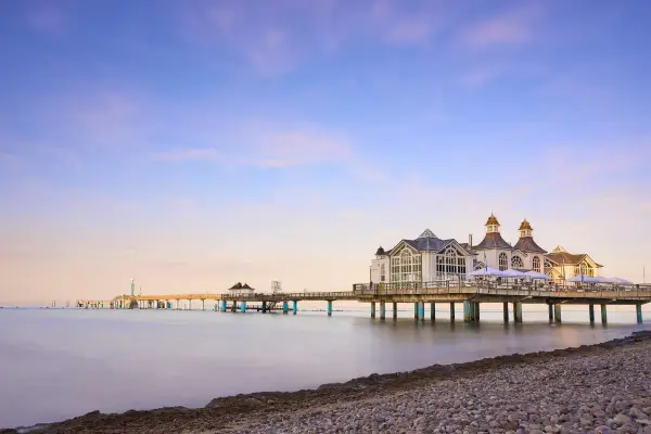 Die Seebrücke im Ostseebad Sellin erstreckt sich ins ruhige Meer. Ein malerischer Anblick bei Sonnenuntergang.